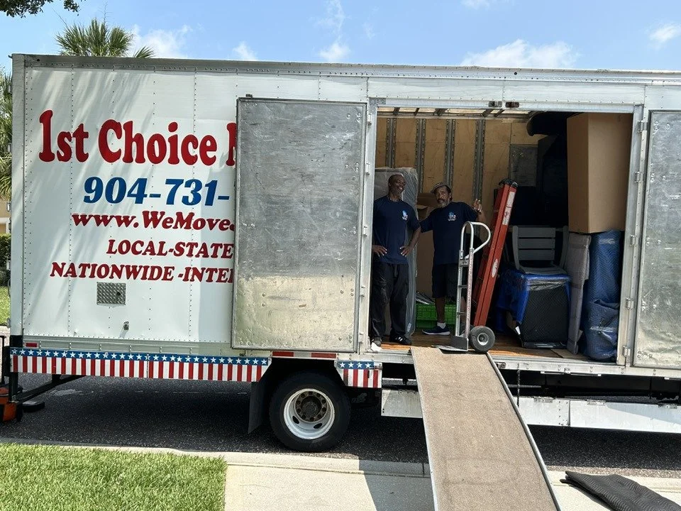 Two 1st Choice Movers team members inside a moving truck with a loading ramp